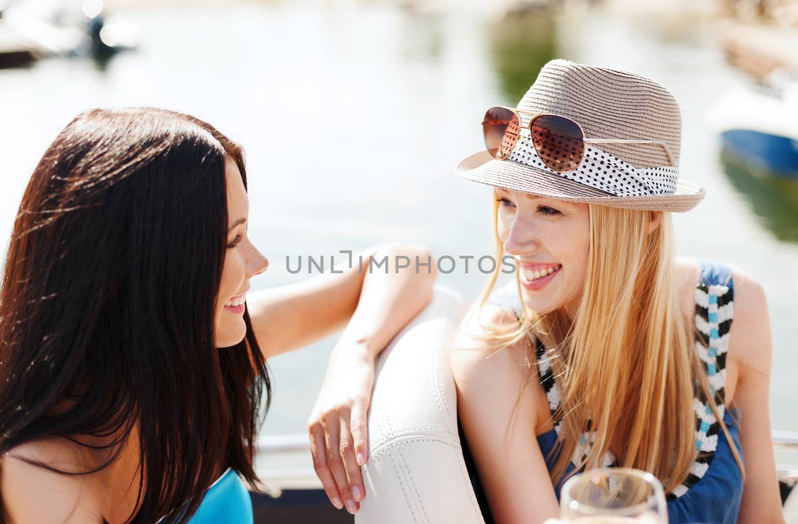 summer holidays and vacation - girls with champagne glasses on boat or yacht