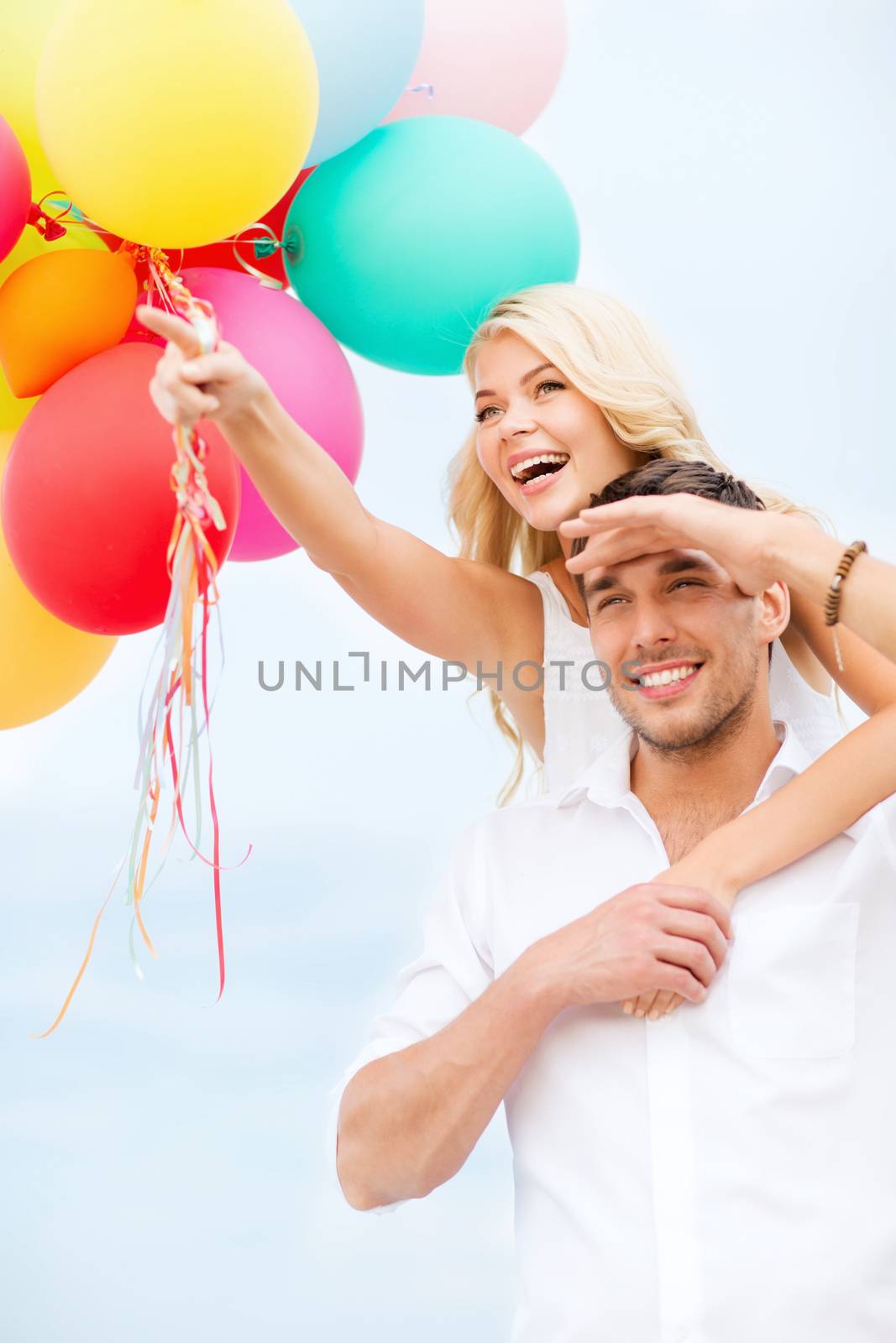 summer holidays, celebration and dating concept - couple with colorful balloons at seaside