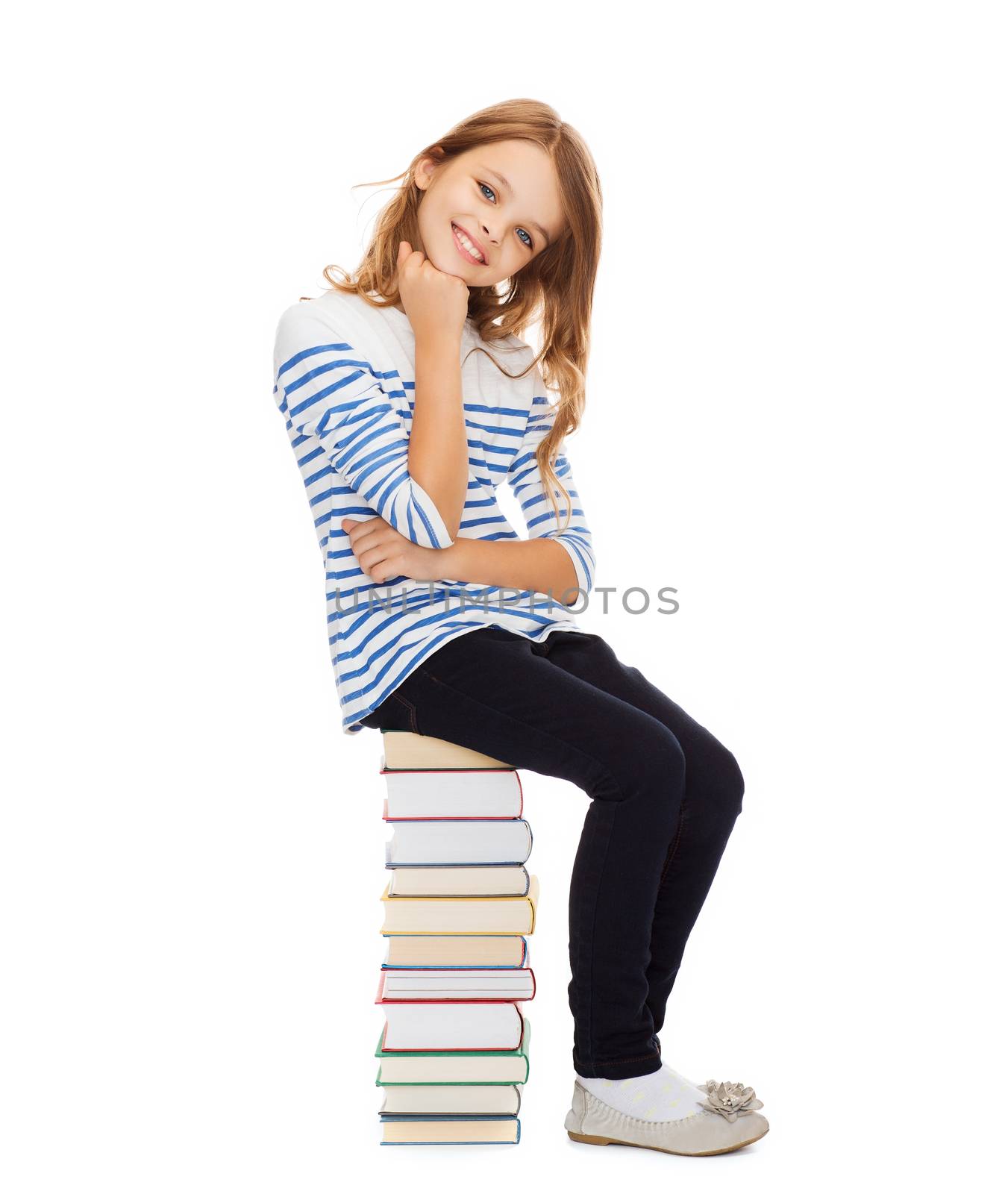 education and school concept - little student girl sitting on stack of books