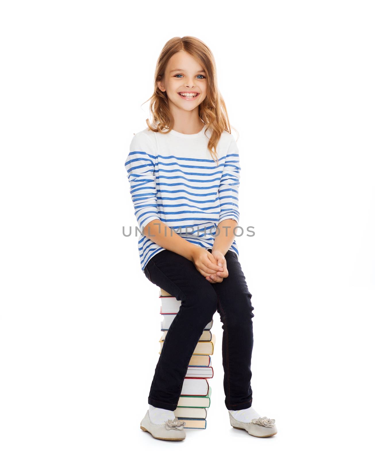 education and school concept - little student girl sitting on stack of books