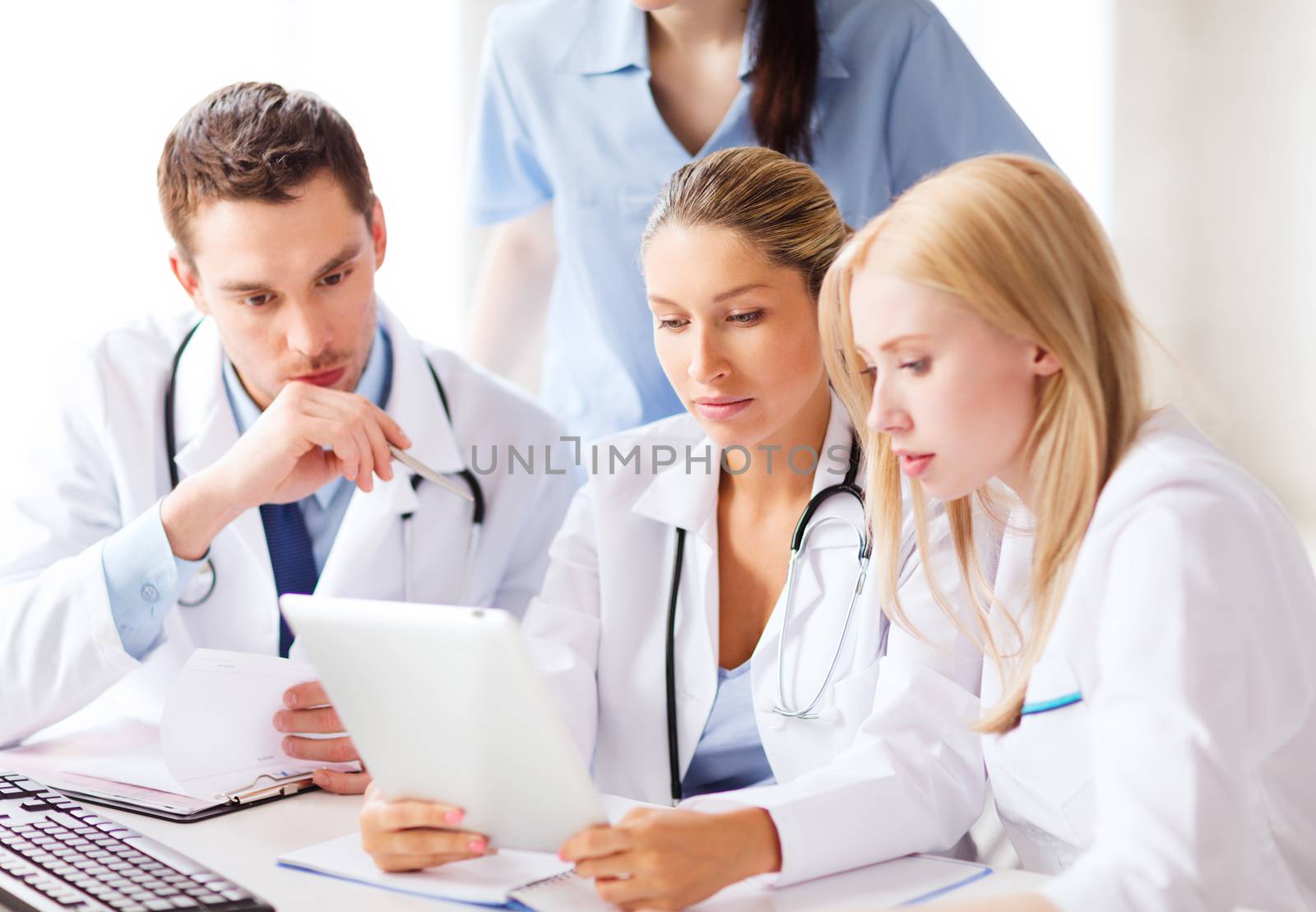 healthcare, medical and technology concept - group of doctors looking at tablet pc