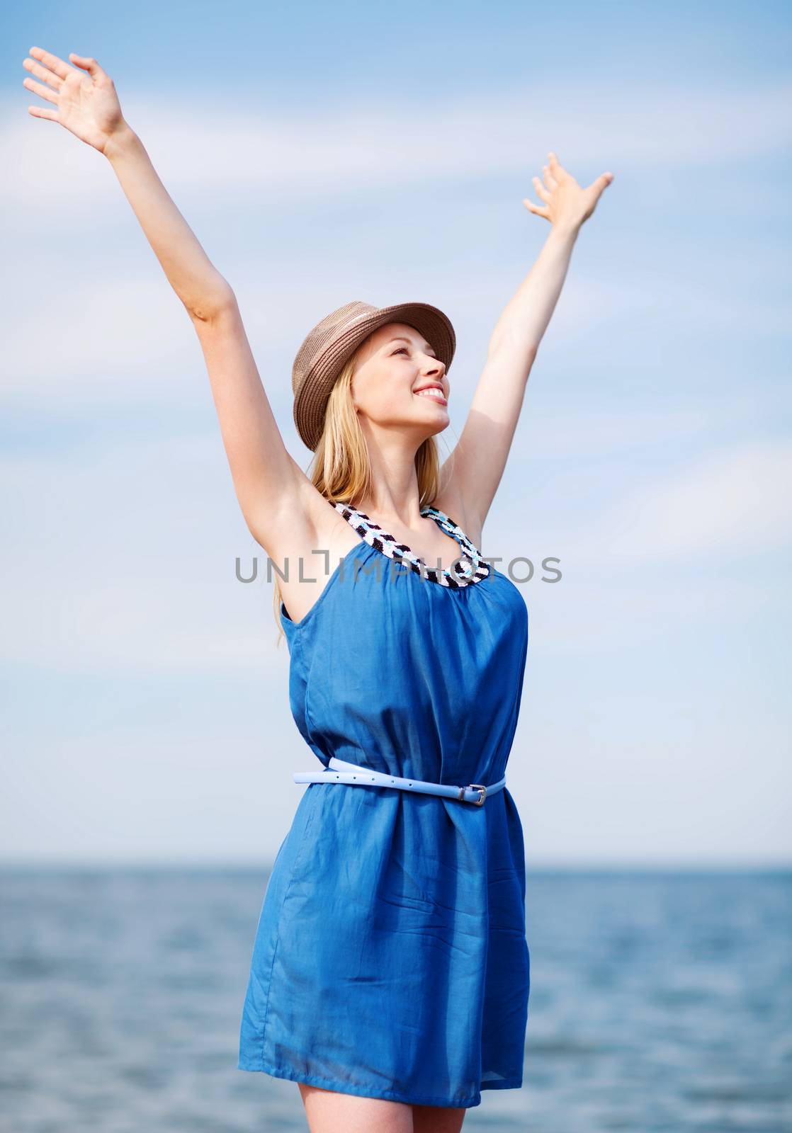 girl with hands up on the beach by dolgachov