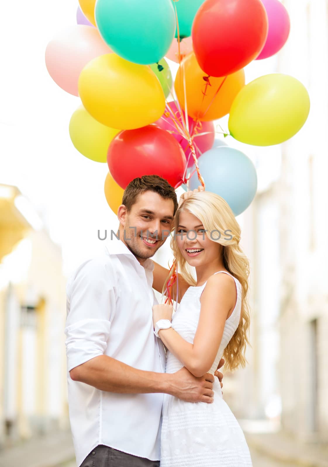 summer holidays, celebration and dating concept - couple with colorful balloons in the city