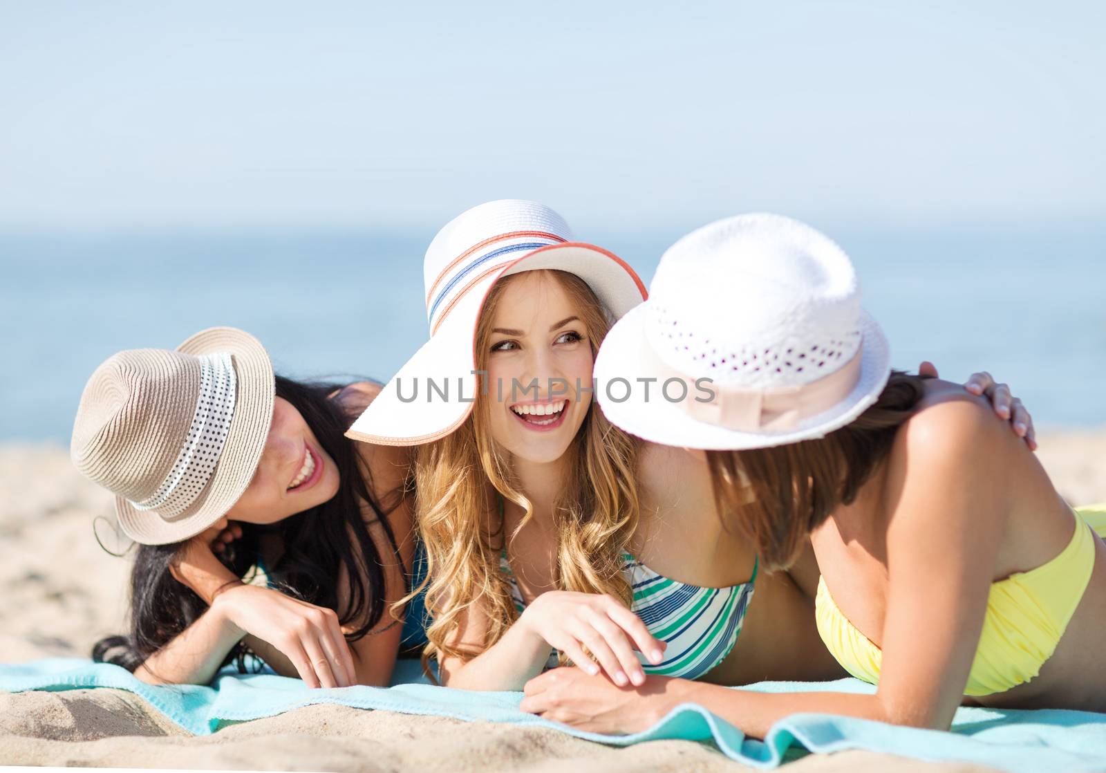 girls sunbathing on the beach by dolgachov