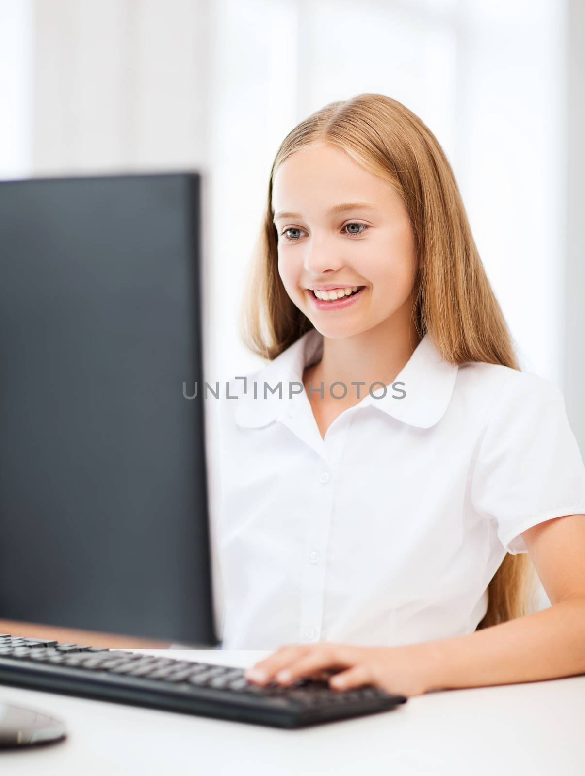 education, school, technology and internet concept - little student girl with computer at school