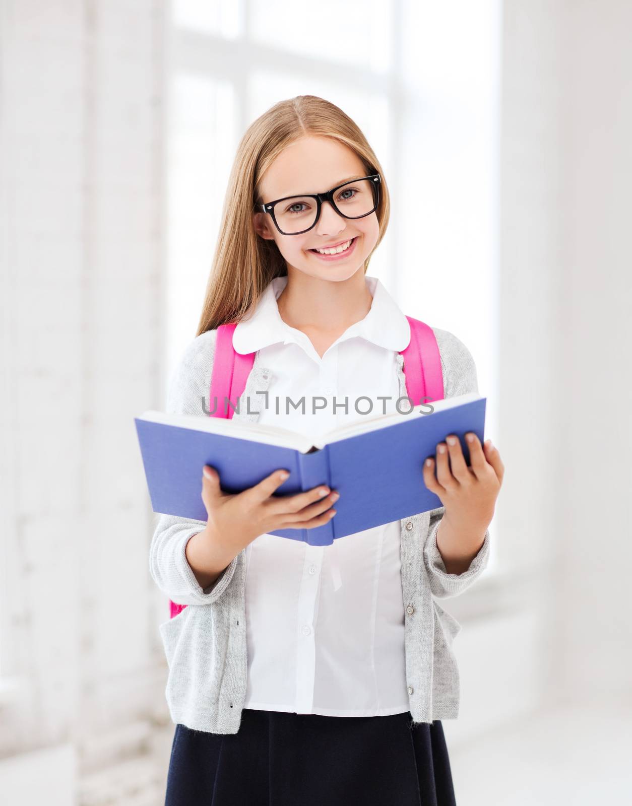 education and school concept - little student girl reading book at school