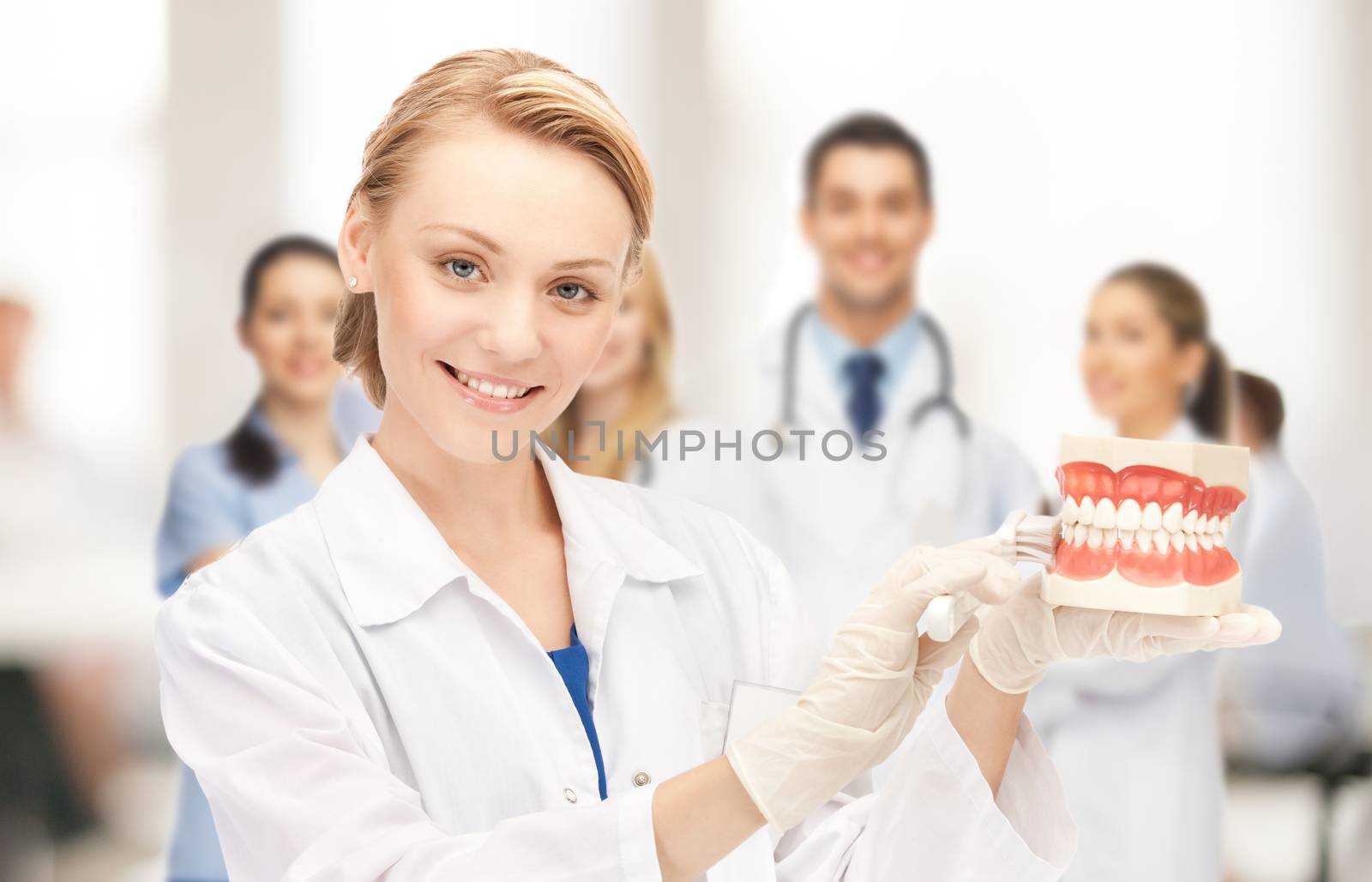 healthcare, medical and stomatology concept - attractive female doctor with toothbrush and big jaws