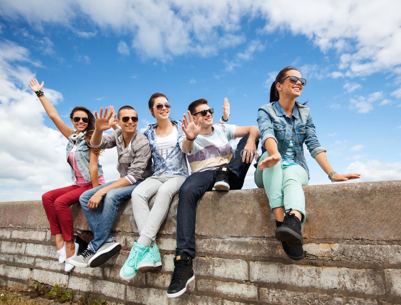 summer holidays and teenage concept - group of teenagers hanging out outside