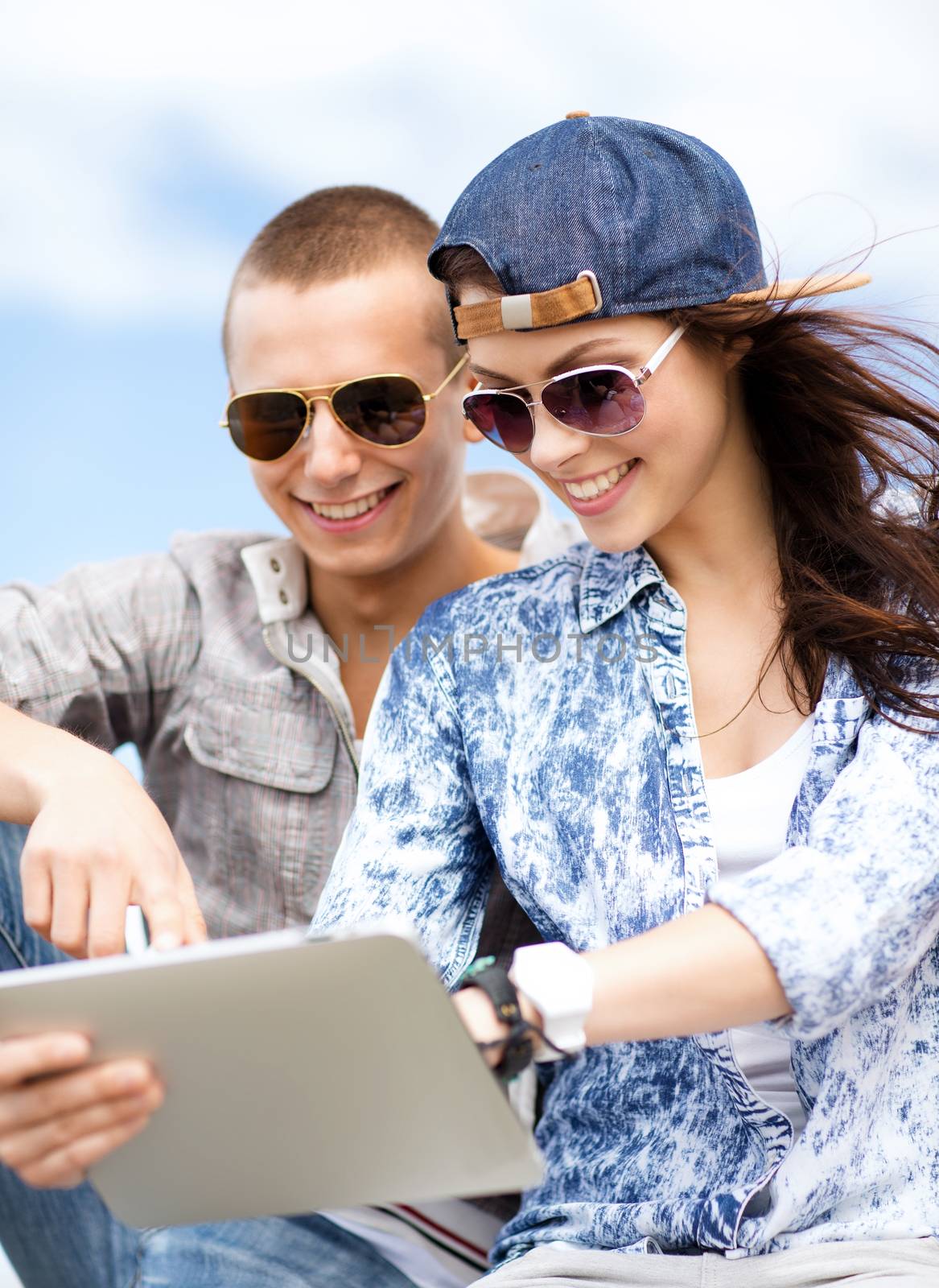 summer holidays, teenage and technology concept - teenagers looking at tablet pc