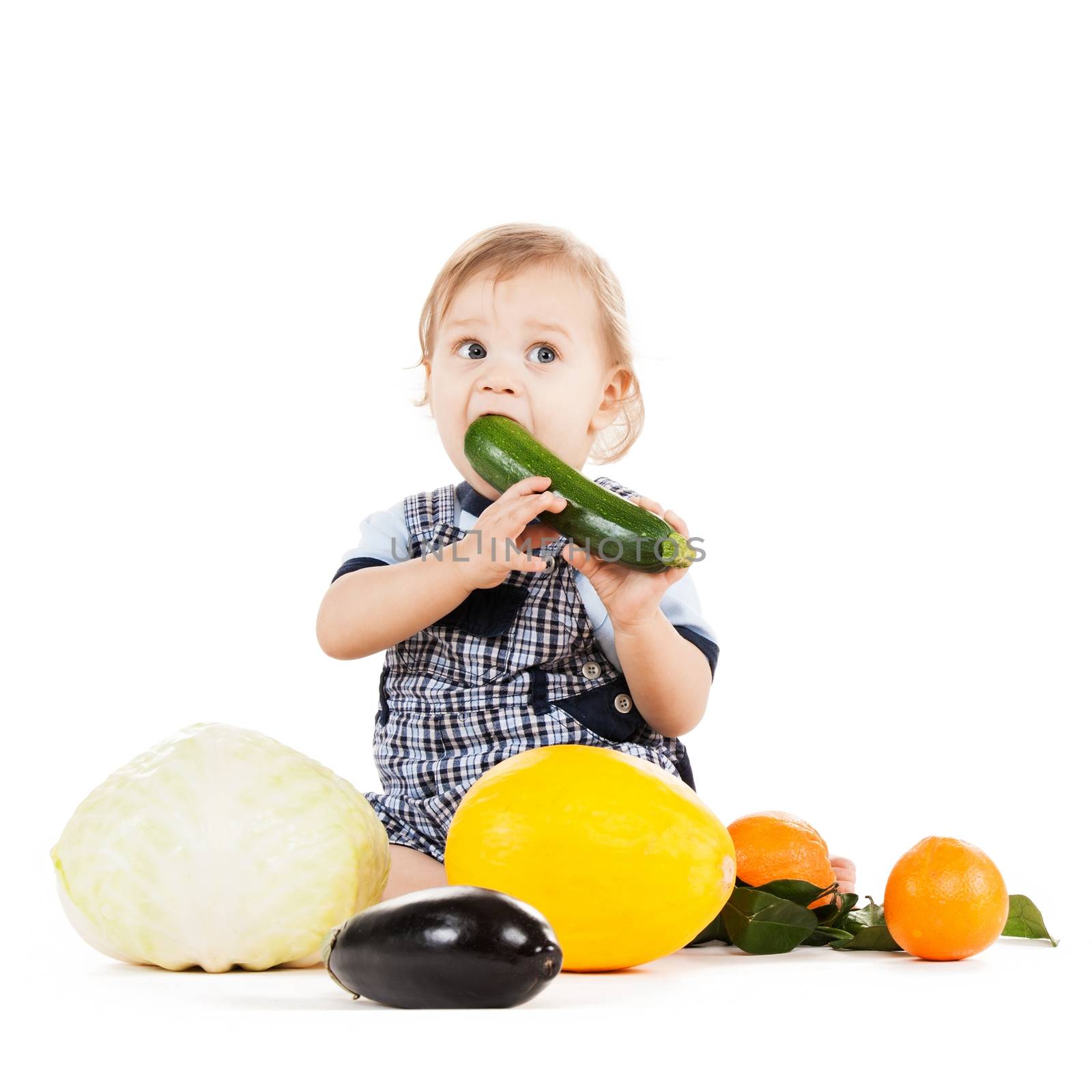 childhood and healthy food concept - cute toddler with vegetables and fruits eating squash
