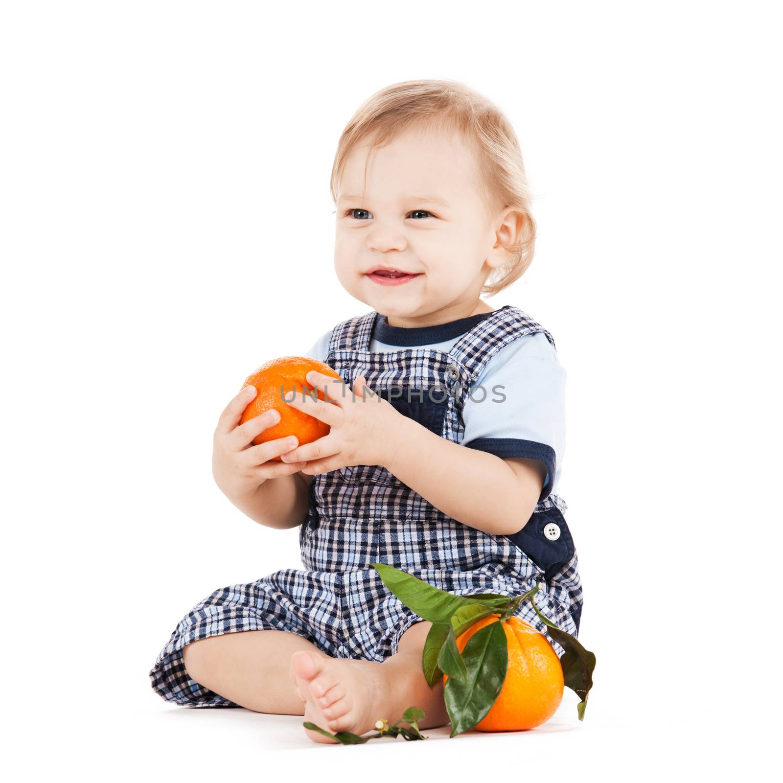 childhood and healthy food concept - cute toddler eating orange