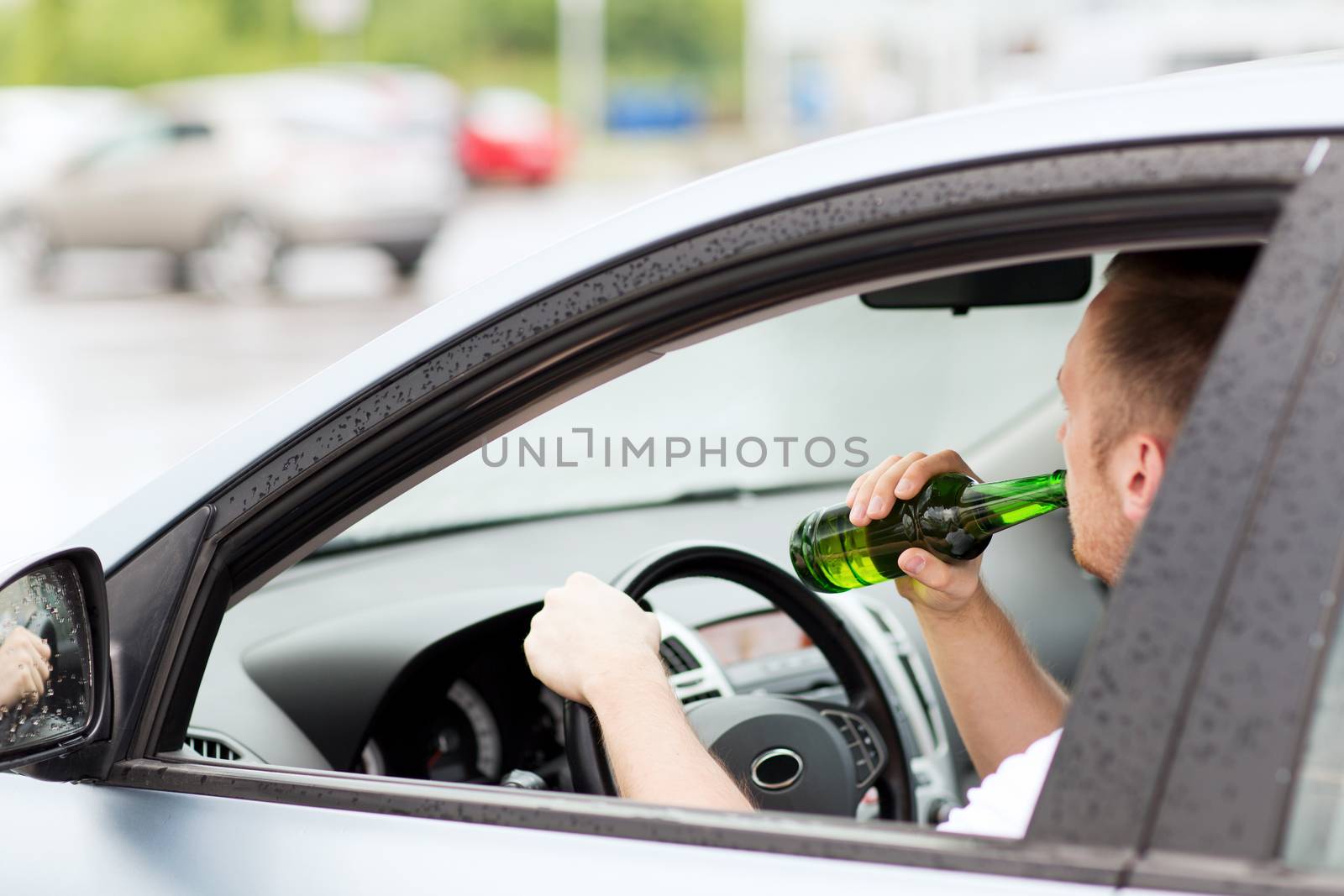 man drinking alcohol while driving the car by dolgachov