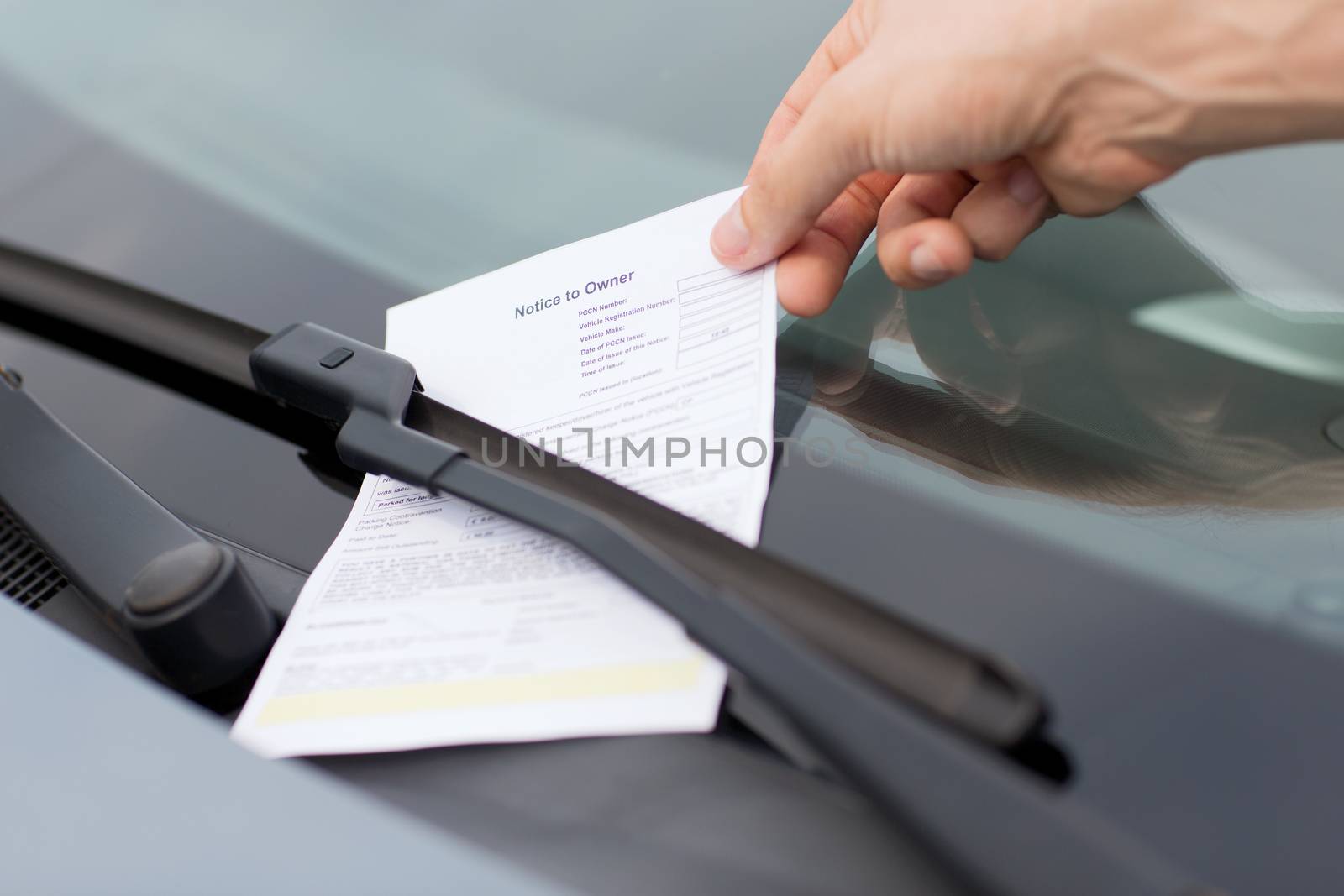 transportation and vehicle concept - parking ticket on car windscreen