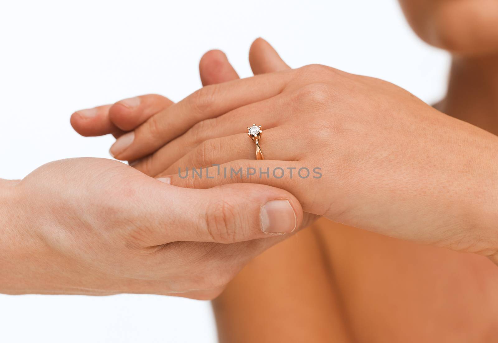 man puts wedding ring on woman hand by dolgachov