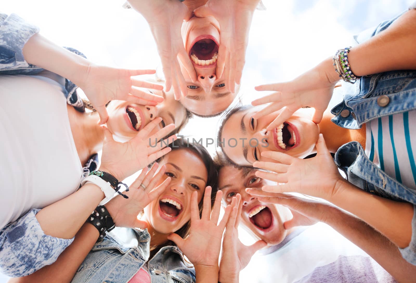 summer holidays and teenage concept - group of teenagers looking down and screaming