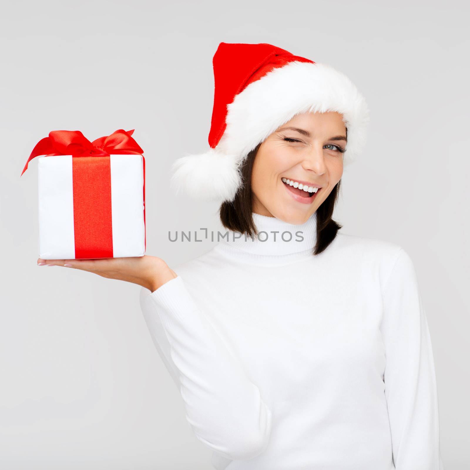 christmas, x-mas, winter, happiness concept - smiling woman in santa helper hat with gift box