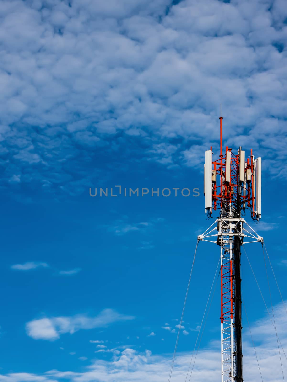 A cell tower on rooftop at nice sky by golengstock