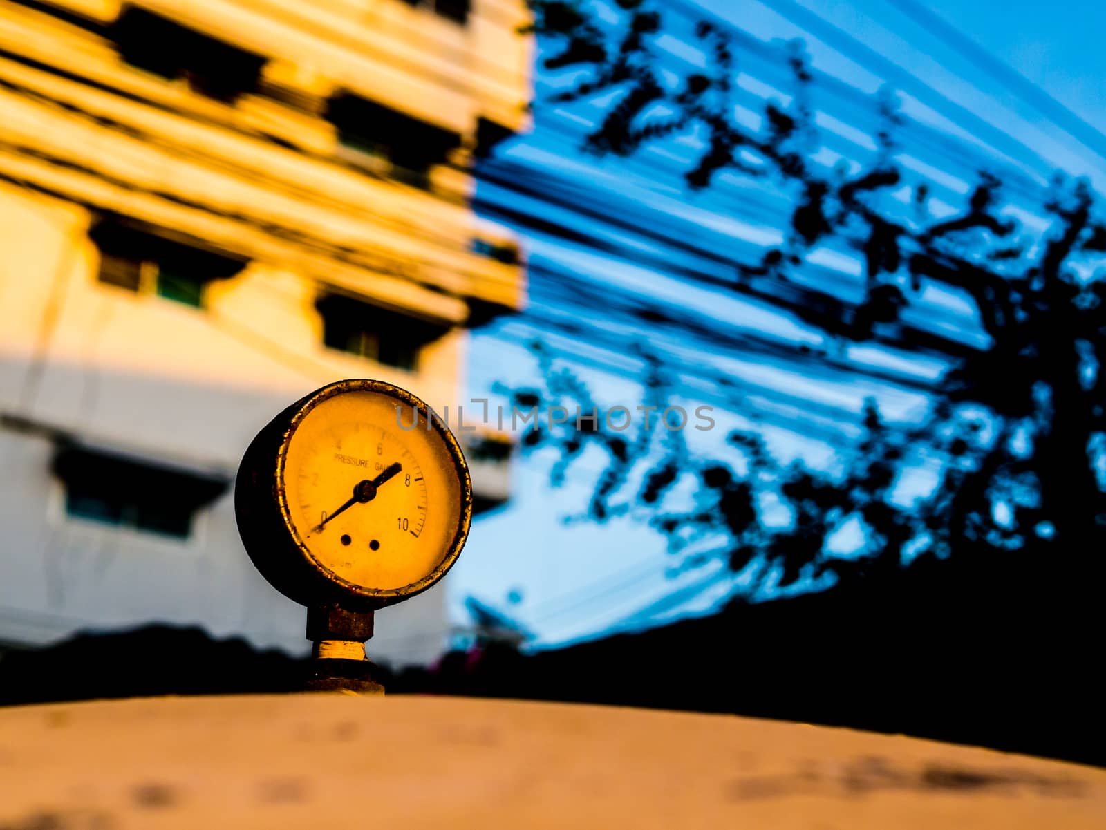 the old pressure gauge of watertank at sunset by golengstock