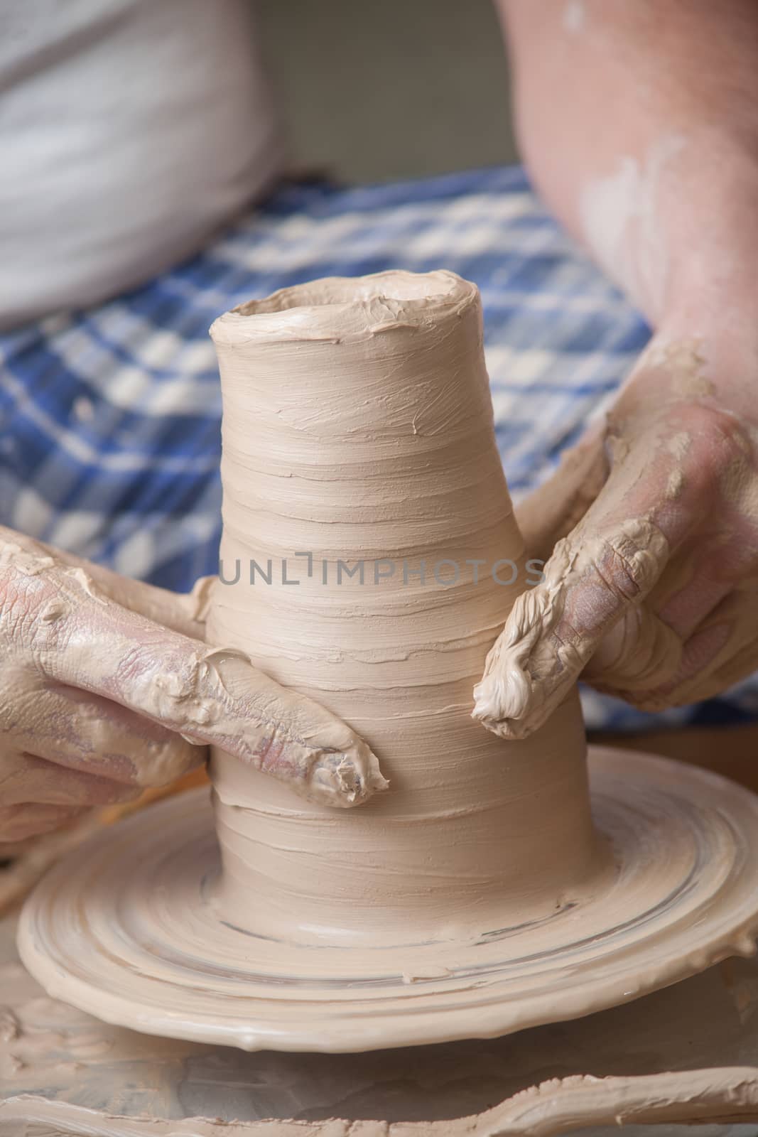 Hands of a potter, creating an earthen jar on the circle