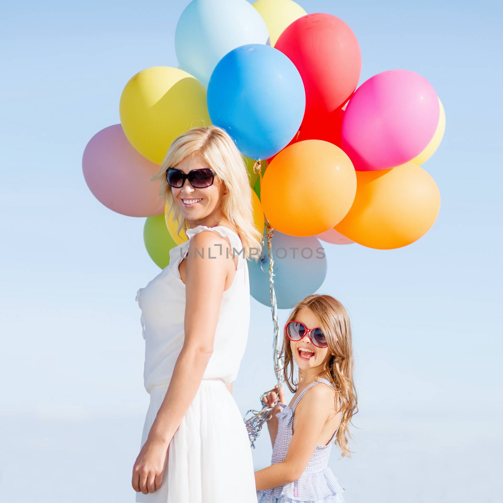 mother and child with colorful balloons by dolgachov