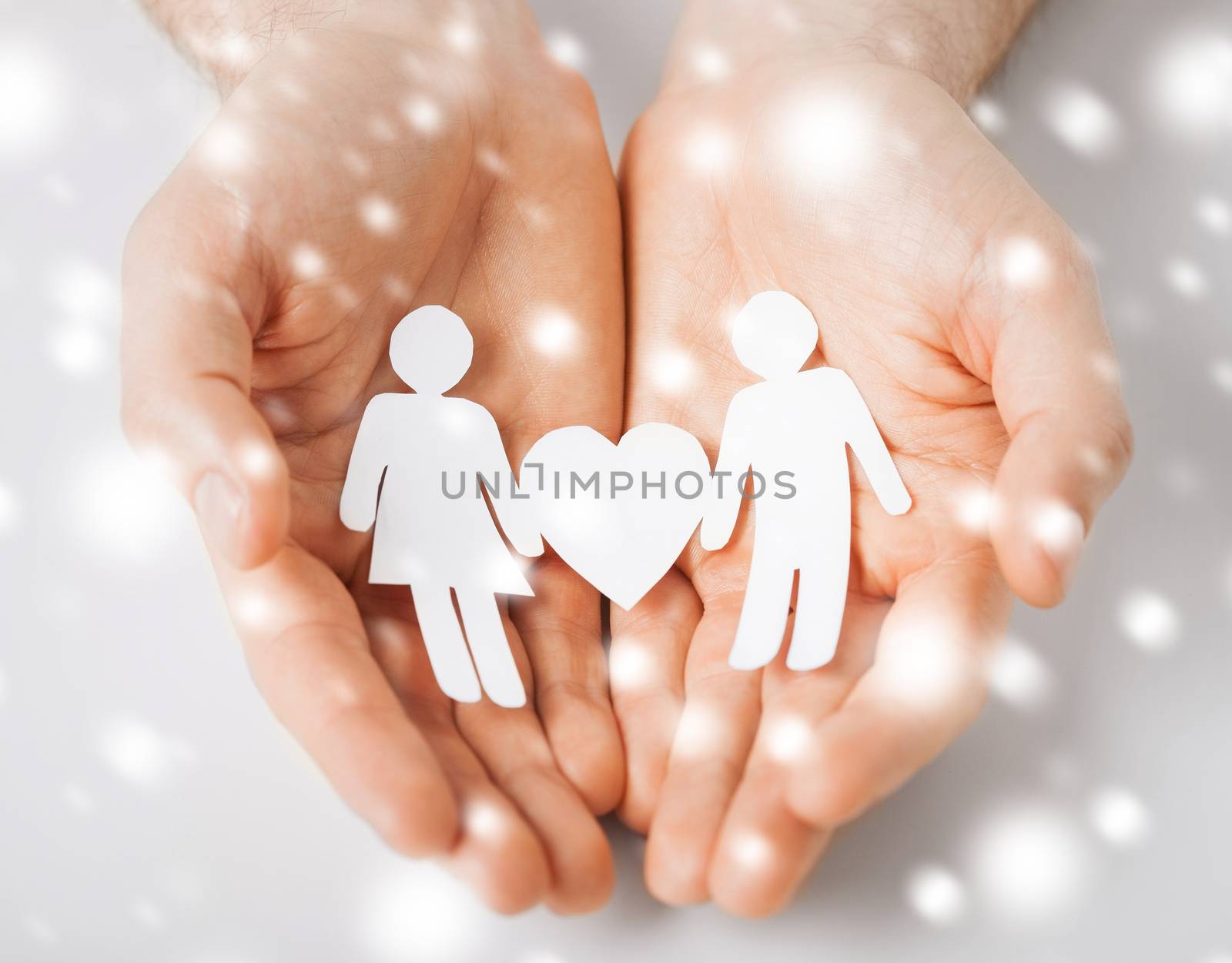 love, romance, safety concept - man hands showing two paper people with heart shape