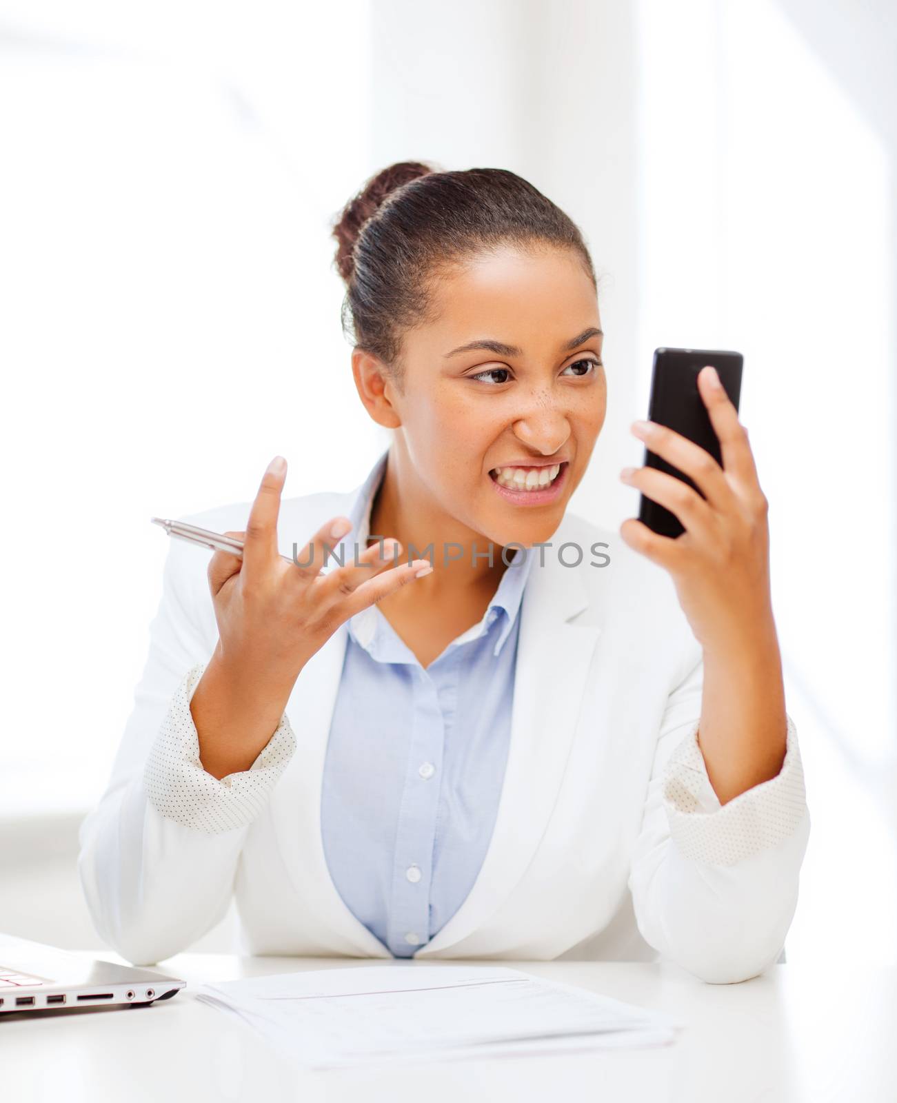 african woman shouting into smartphone by dolgachov