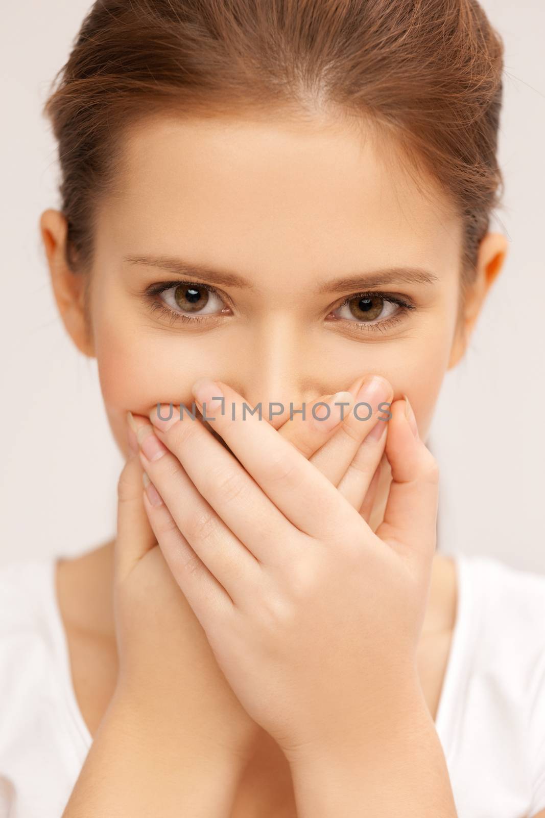 face of beautiful teenage girl covering her mouth by dolgachov