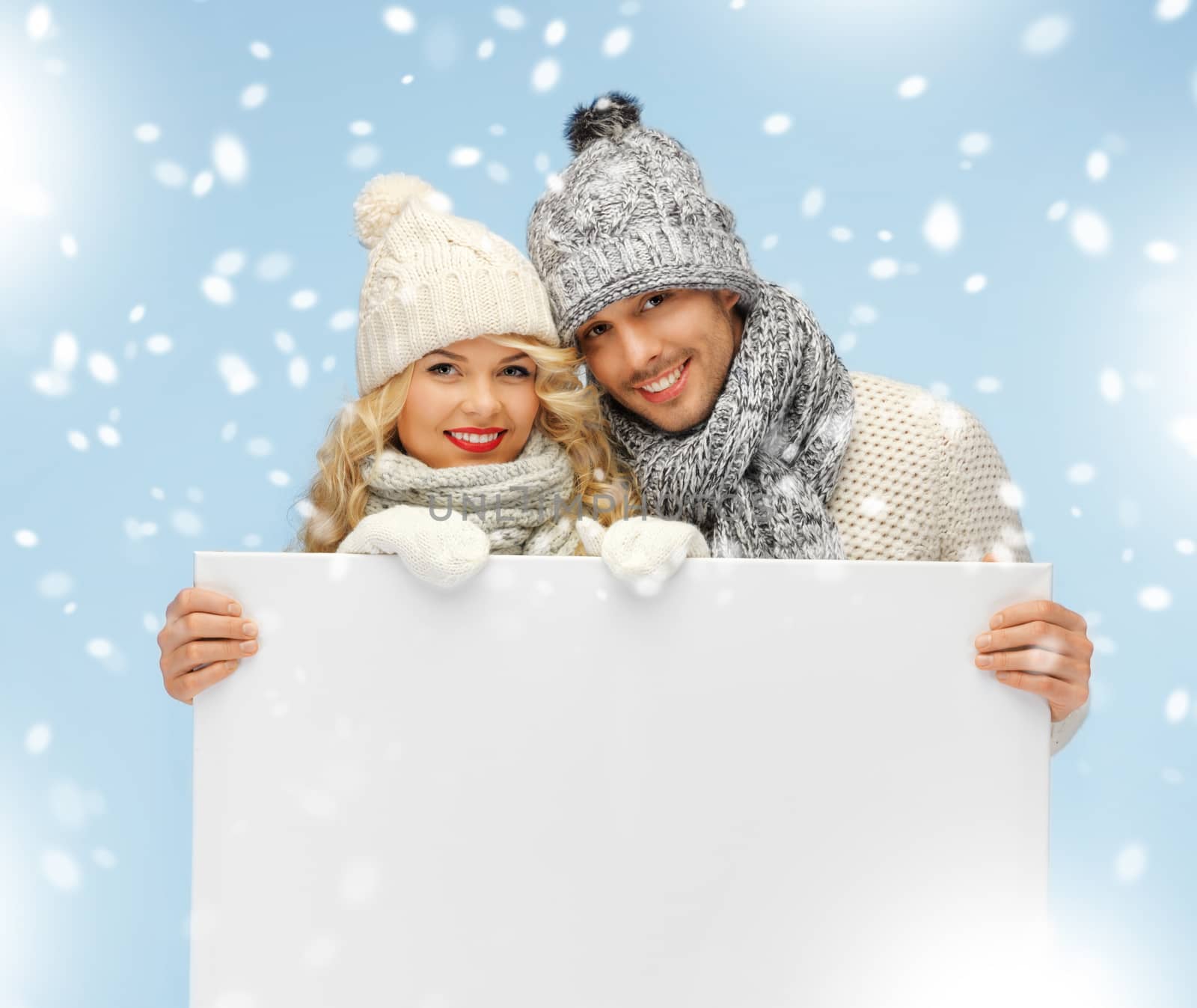 couple in a winter clothes holding blank board by dolgachov