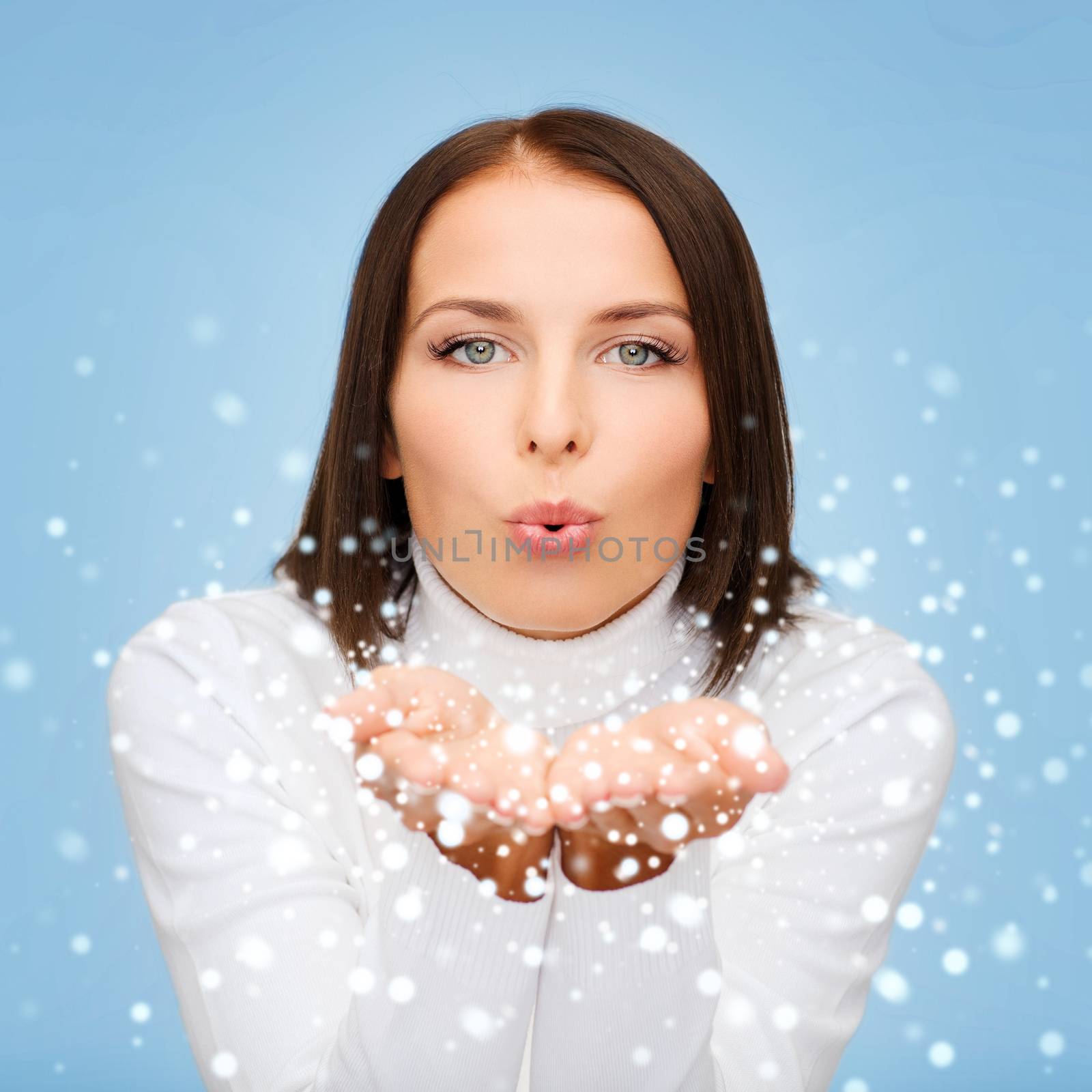 winter, people, happiness concept - happy woman in white sweater blowing on palms