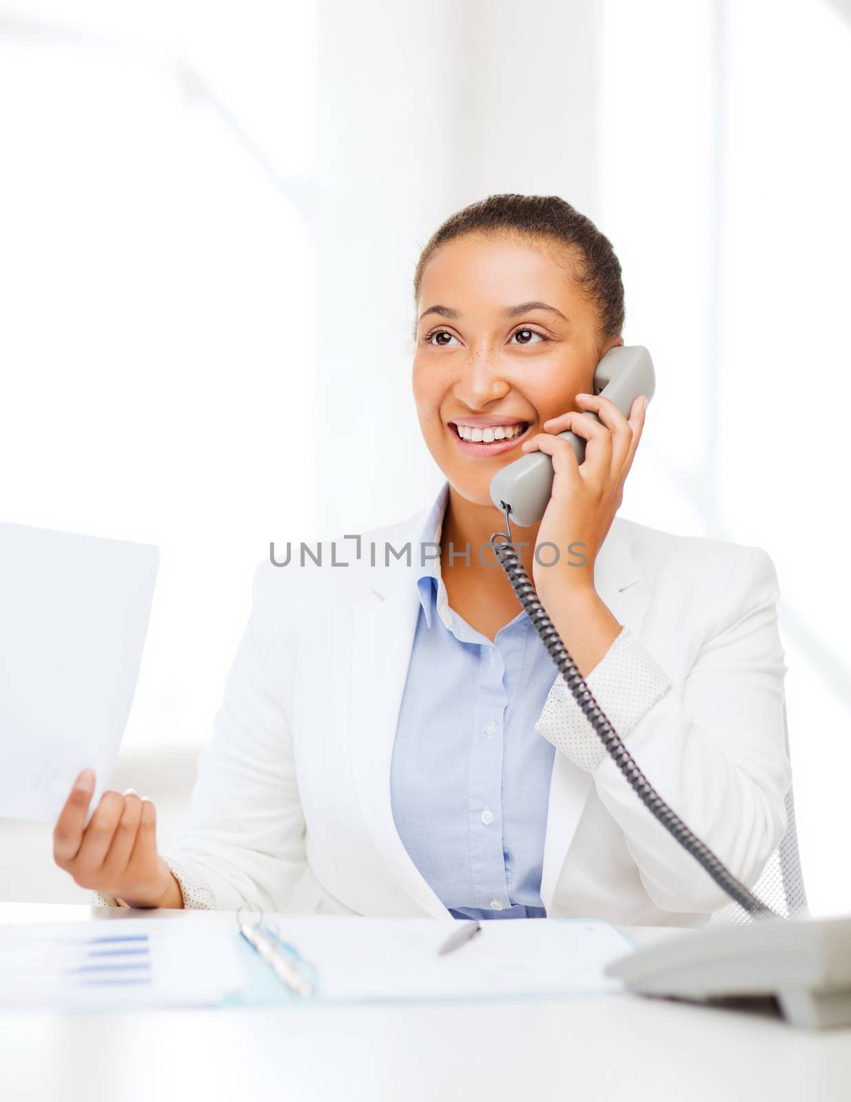 african businesswoman with phone in office by dolgachov