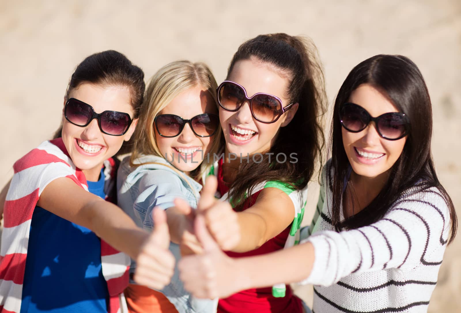 teenage girls or young women showing thumbs up by dolgachov