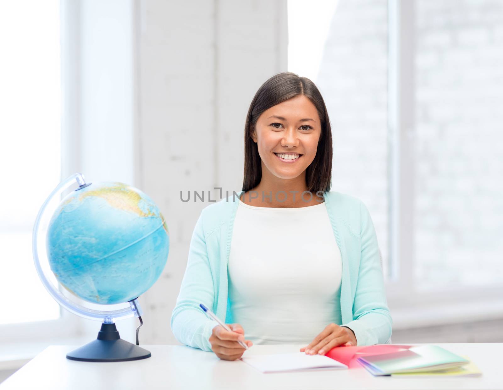 education and school, travel concept - female teacher with globe and notepad