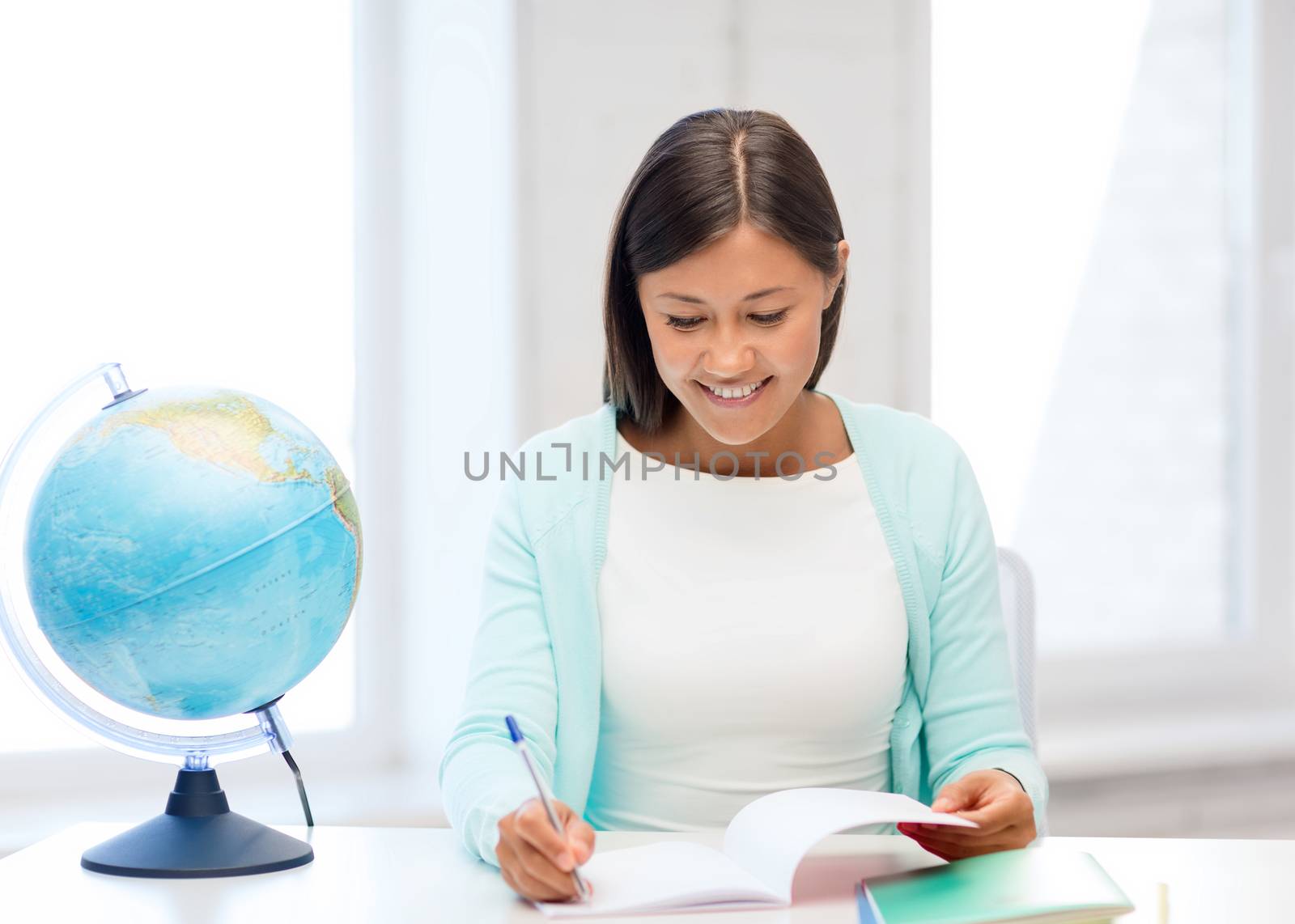 education and school, travel concept - female teacher with globe and notepad