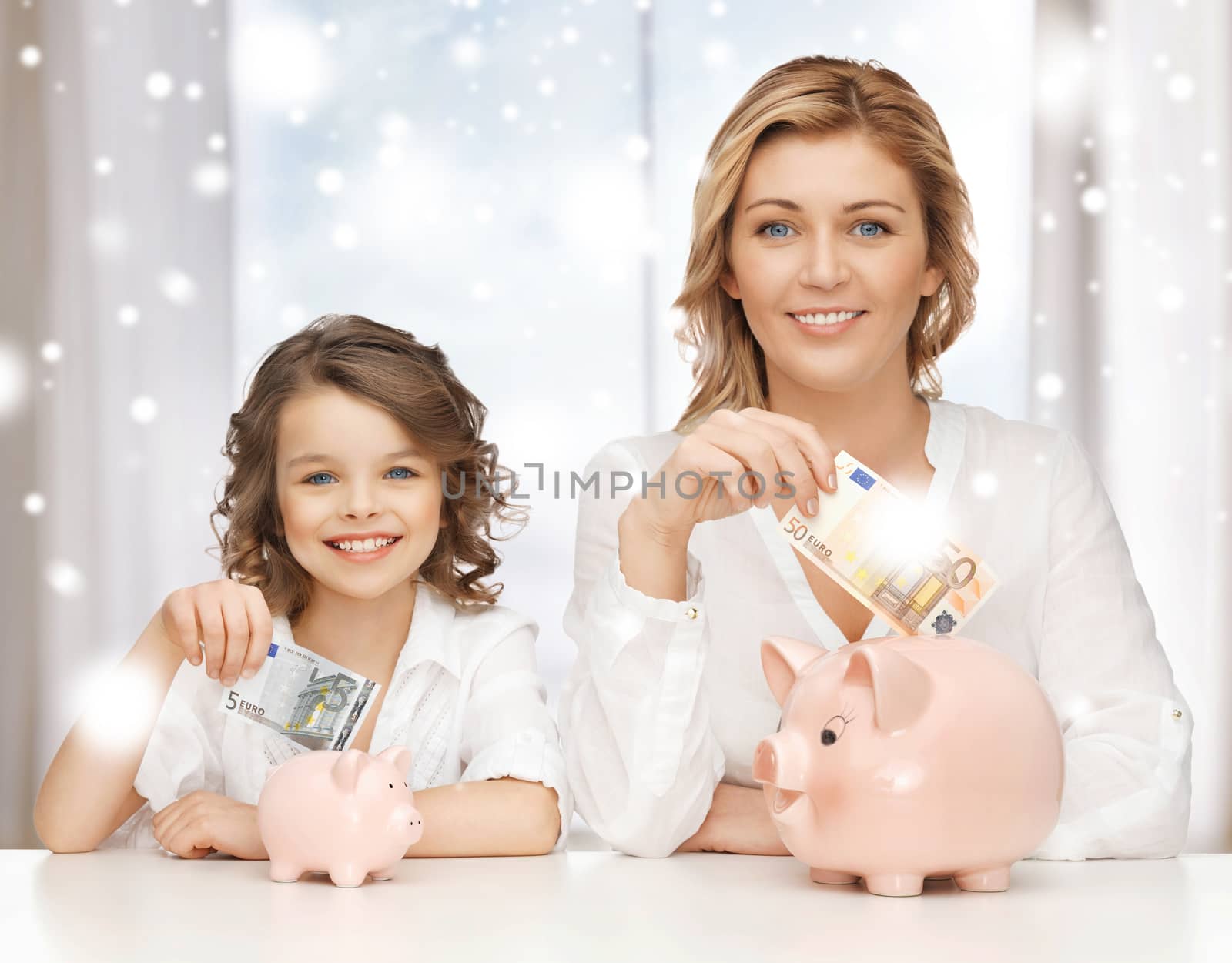 mother and daughter with piggy banks and money by dolgachov