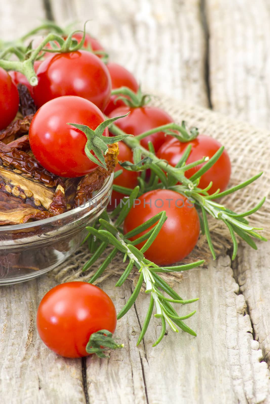 fresh and dried tomatoes on wooden background