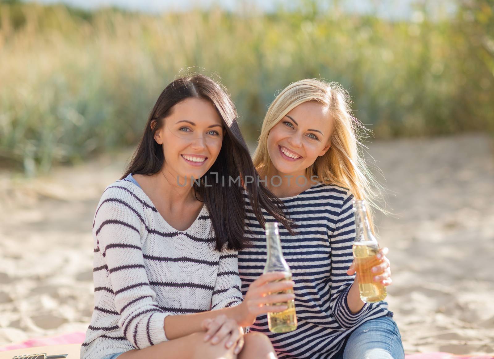 summer holidays and vacation concept - girls with drinks on the beach