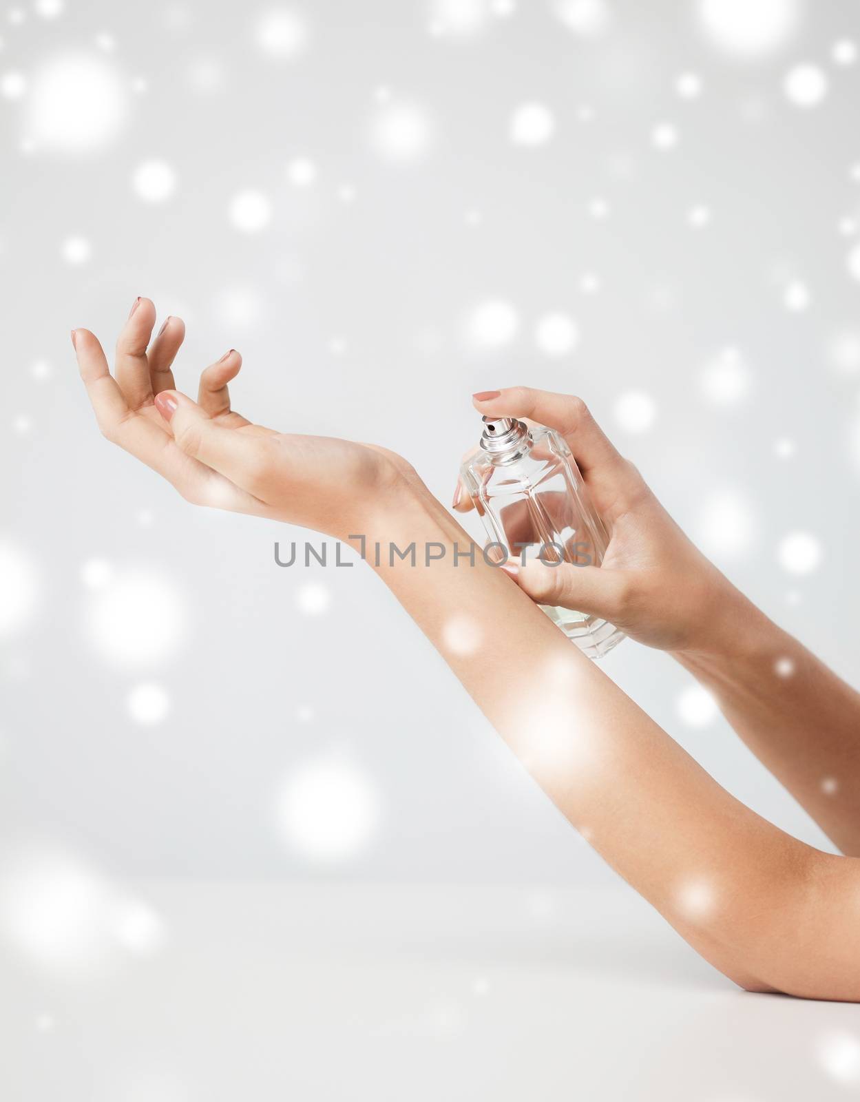health and beauty concept - woman hands spraying perfume