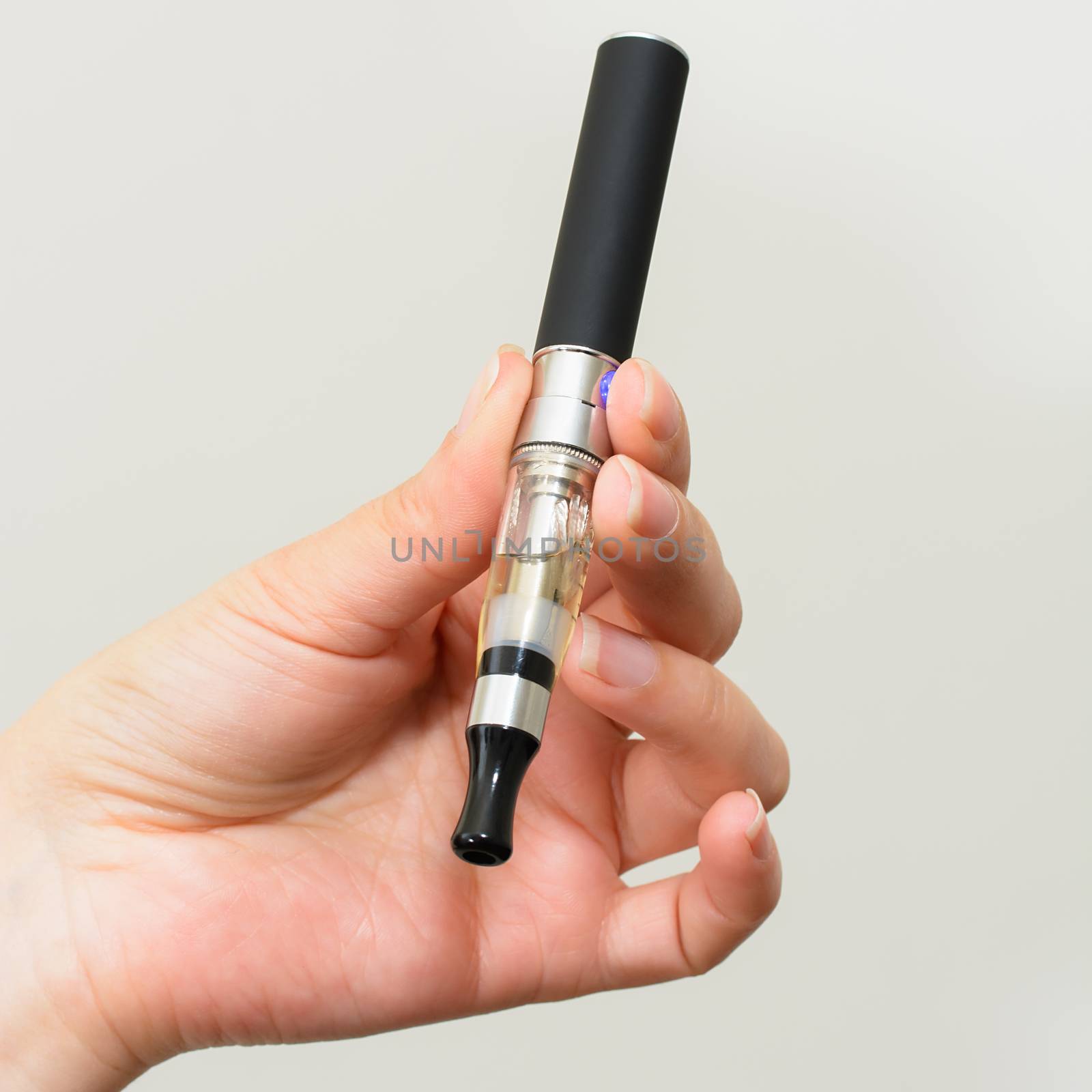 Close up of a woman hand holding an electronic cigarette 