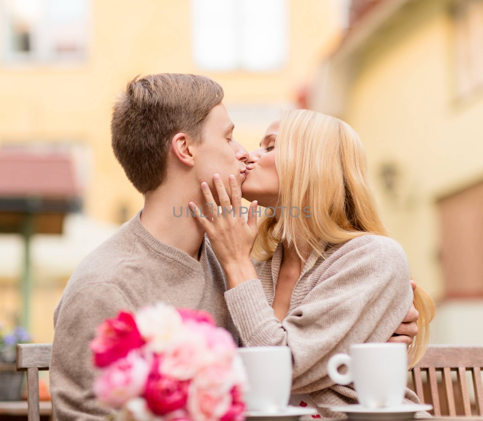 romantic happy couple kissing in the cafe by dolgachov