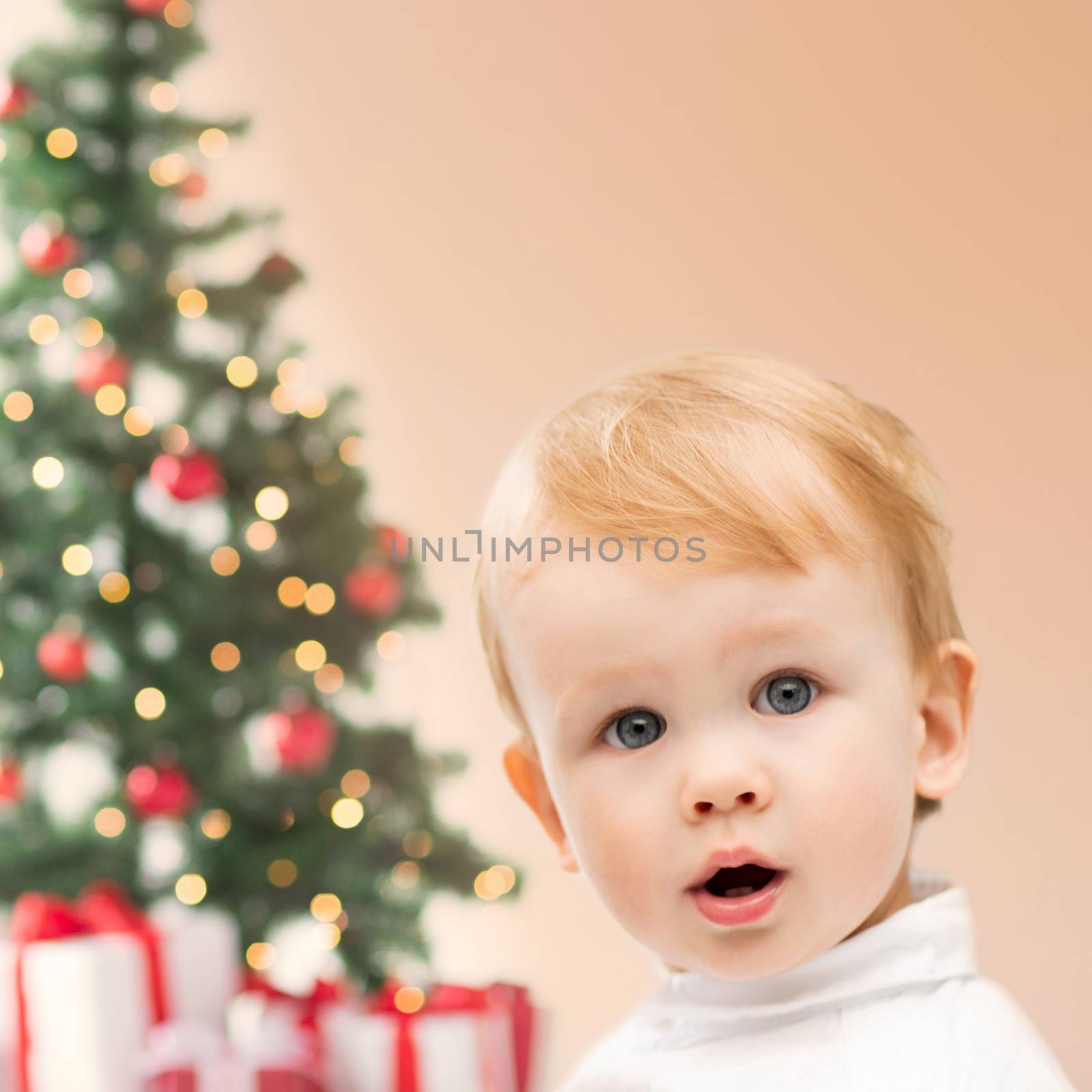 winter, people, x-mas, happiness concept - happy little boy with christmas tree and gifts