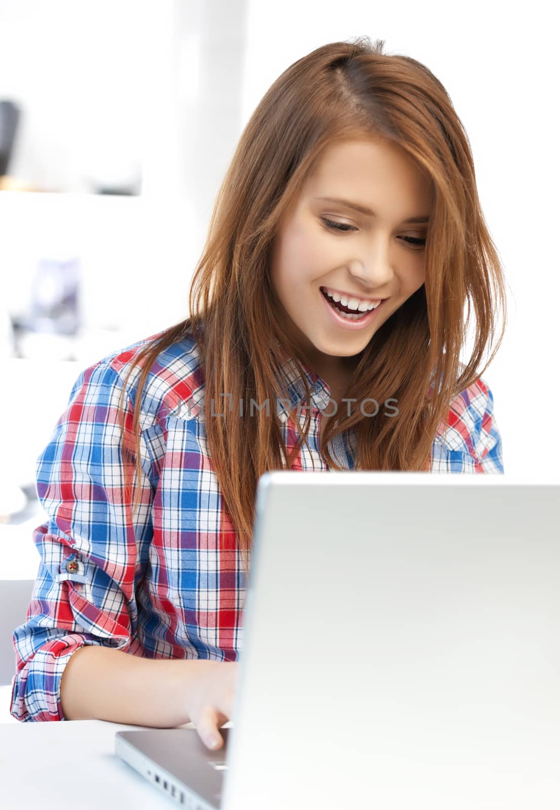 smiling student girl with laptop at school by dolgachov