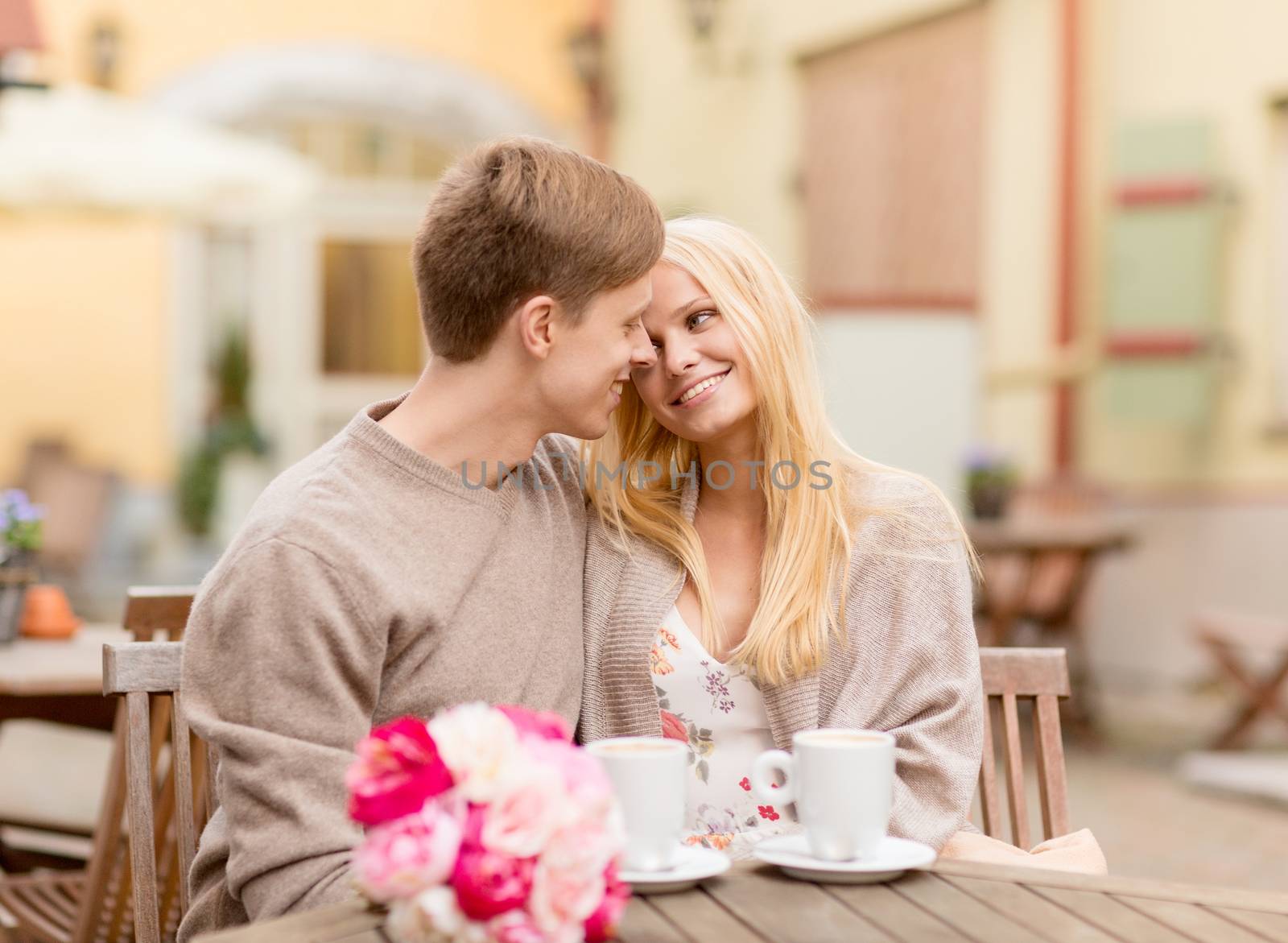 romantic happy couple kissing in the cafe by dolgachov