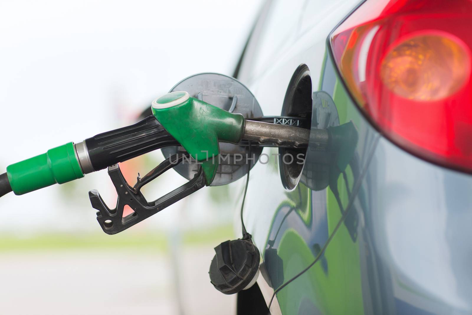 pumping gasoline fuel in car at gas station by dolgachov