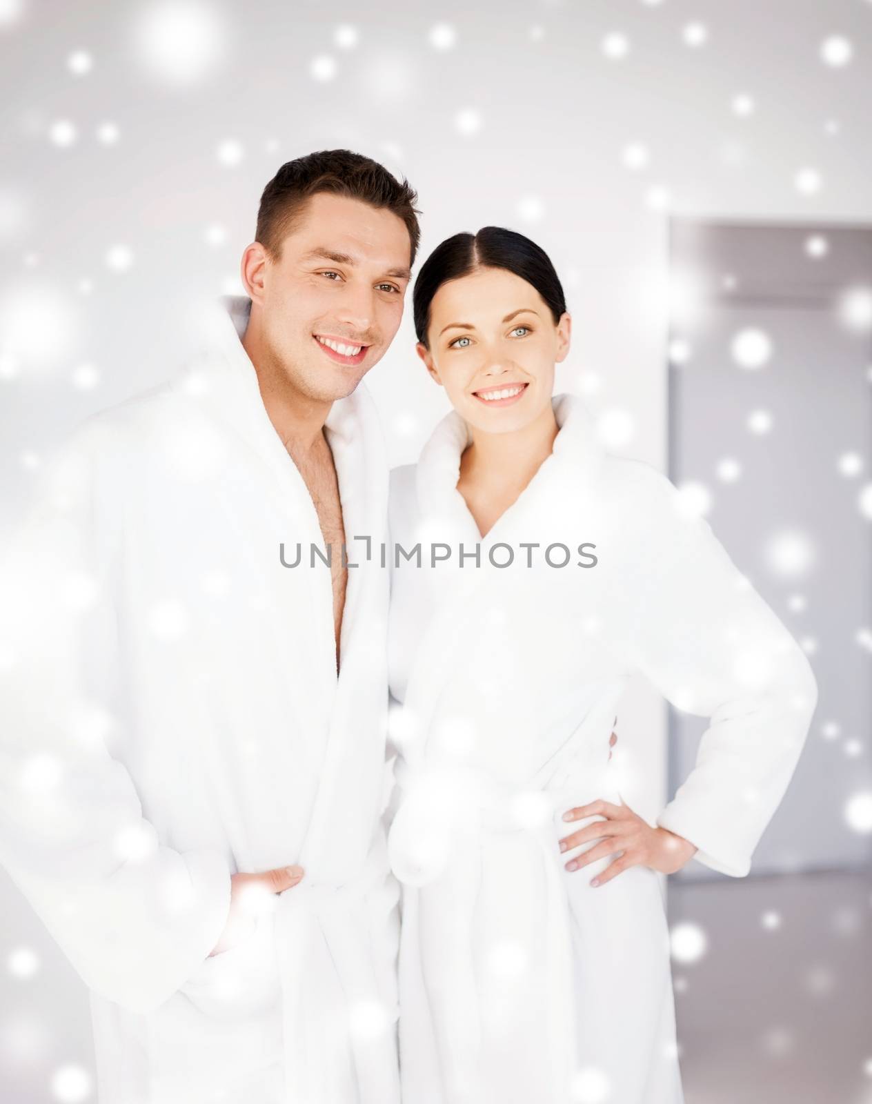 health and beauty concept - couple in spa salon in white bathrobes