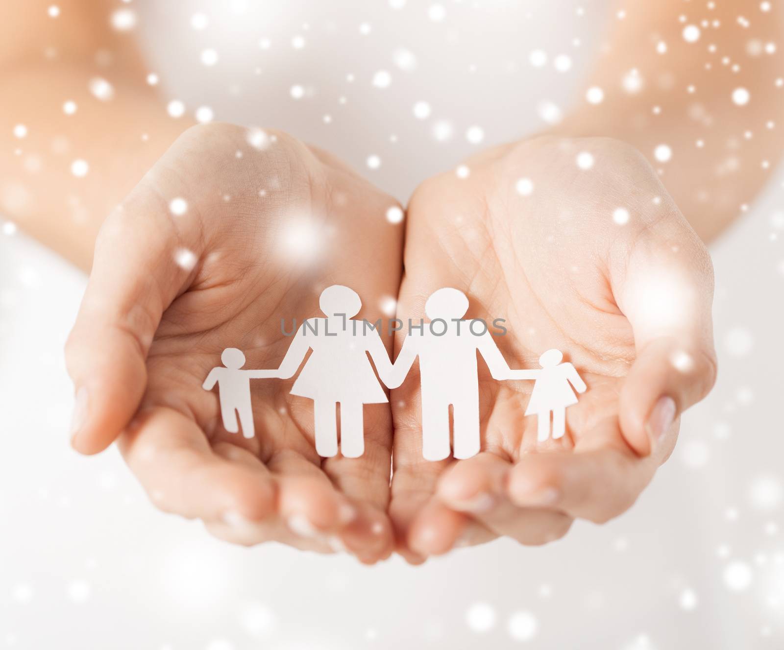 family, children, christmas, x-mas and happy people concept - woman cupped hands showing paper man family