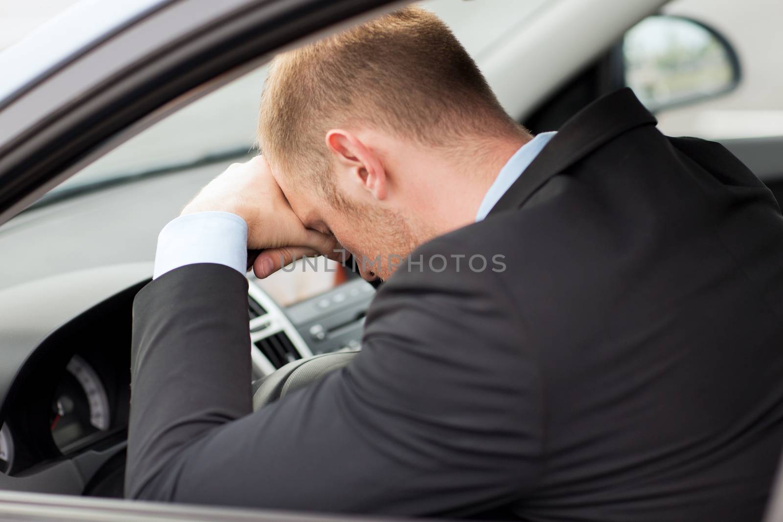 tired businessman or taxi car driver by dolgachov