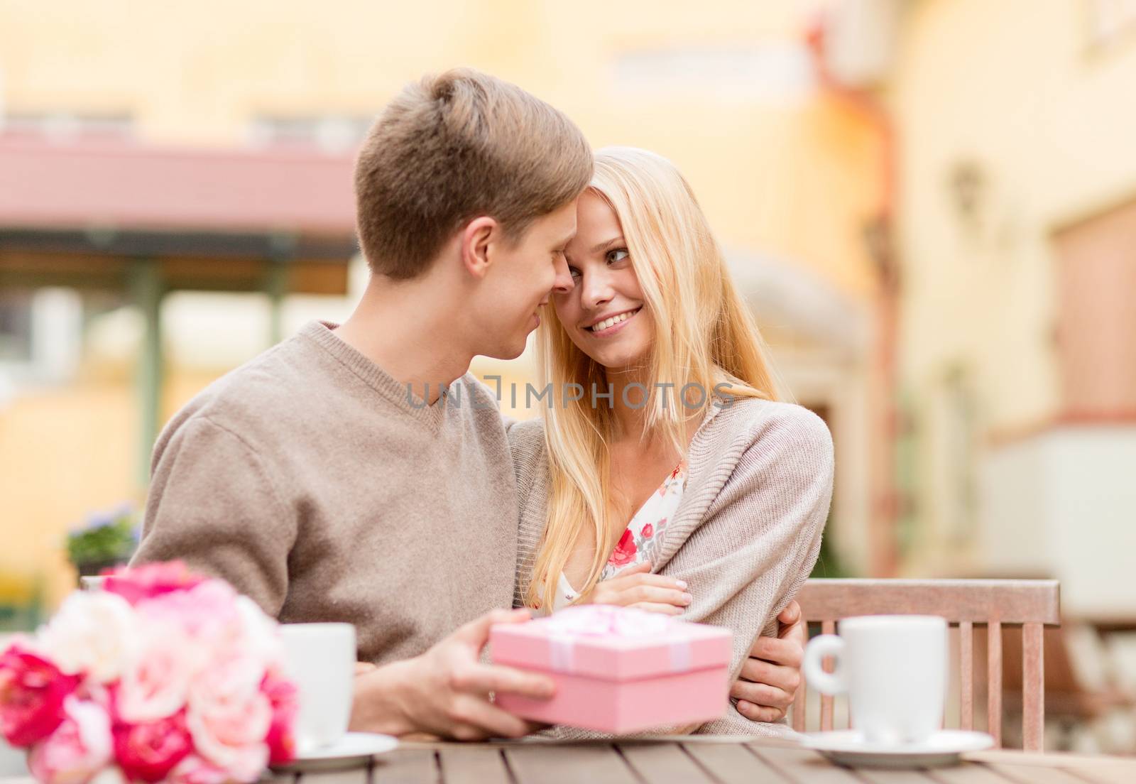 romantic happy couple with gift in the cafe by dolgachov