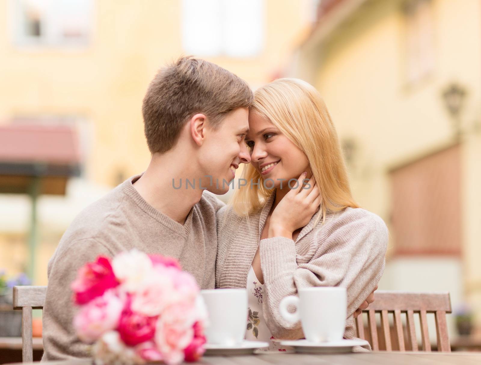 summer holidays, love, travel, tourism, relationship and dating concept - romantic happy couple kissing in the cafe