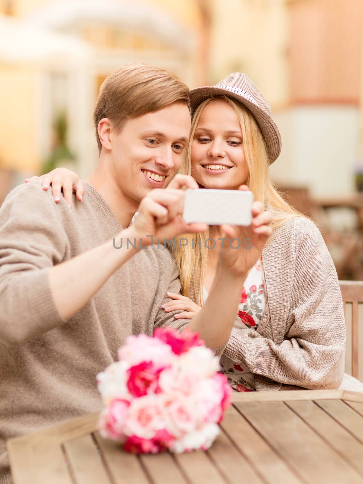 summer holidays, dating and technology concept - couple taking picture with smartphone at cafe in the city