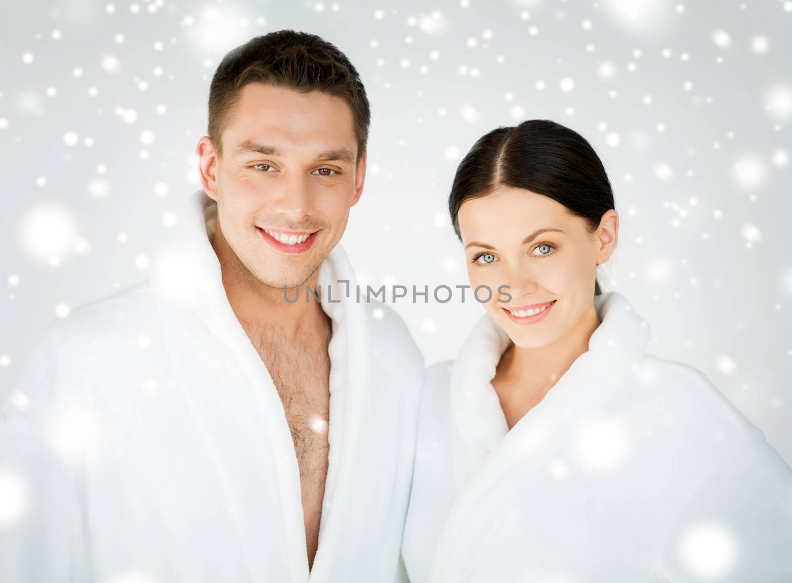 health and beauty concept - couple in spa salon in white bathrobes
